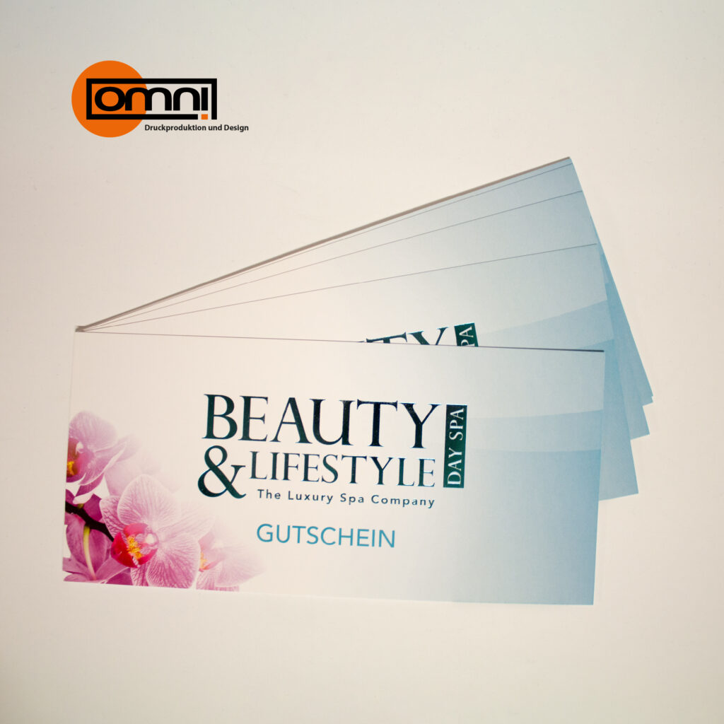 Gutschein wo beauty & lifestyle bedruckt steht mit rosa Blumen und hellblauer Hintergrund. Omnidruck Logo oben angezeigt.